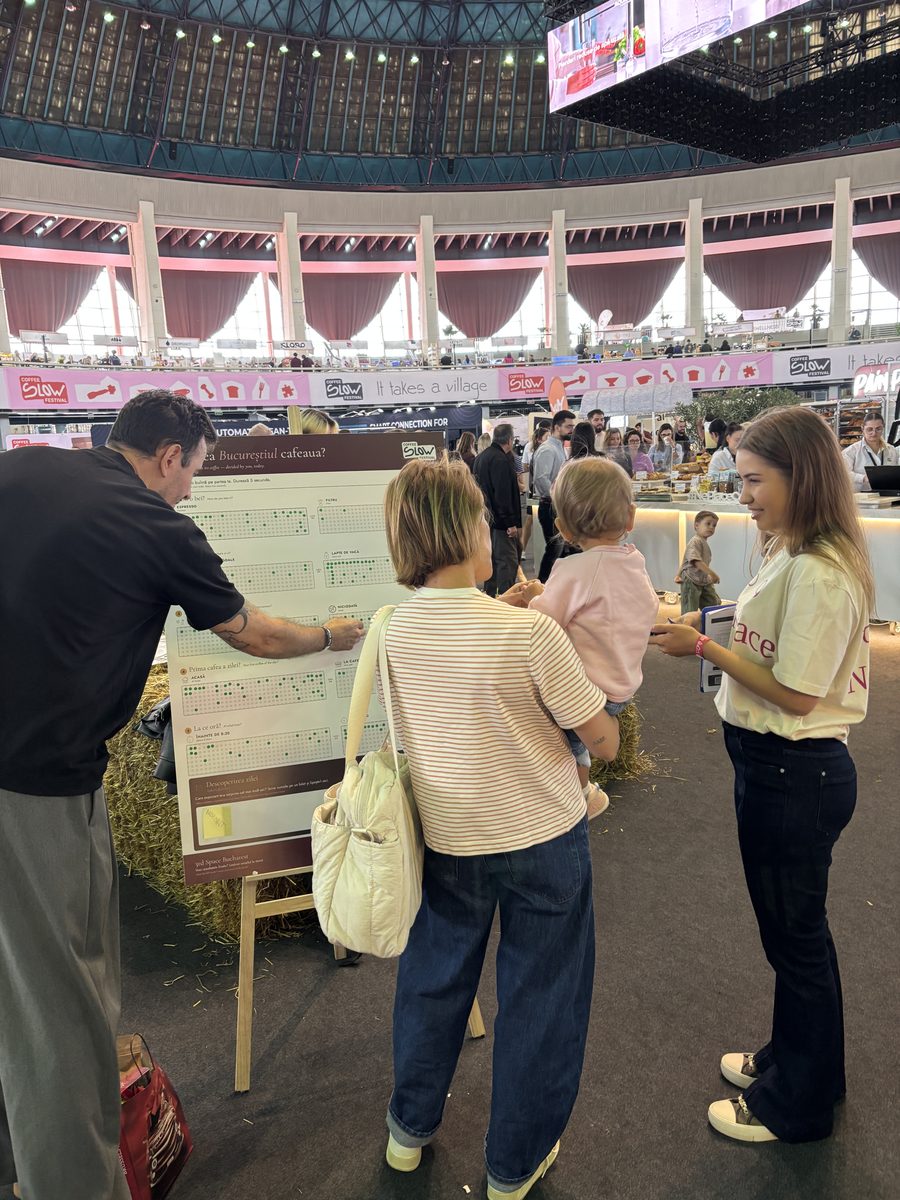 A family placing their stickers on the coffee vote wall in Bucharest