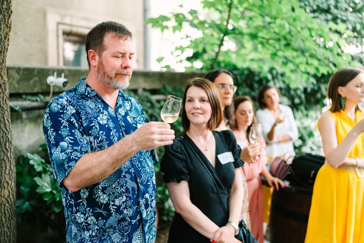 Guests tasting Romanian wine in a Bucharest courtyard at a 3rd Space Bucharest social