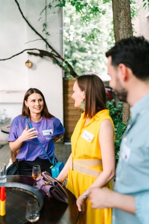 Two guests in conversation at the wine tasting, glasses on a wine-barrel table